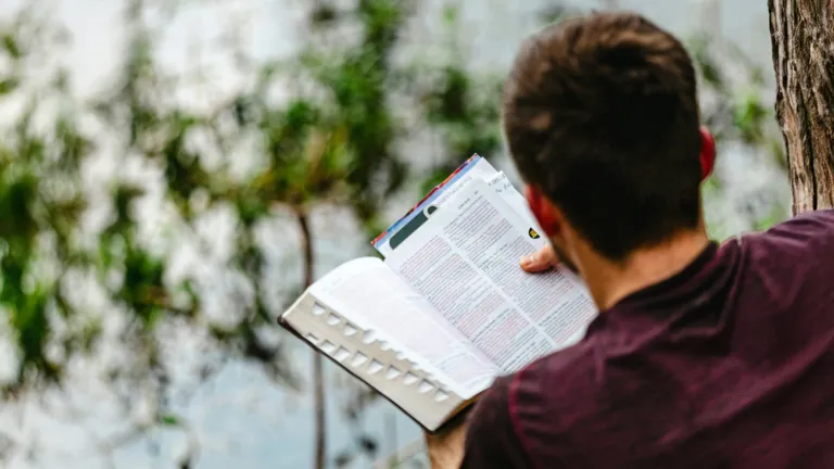 a man reading a Bible outside
