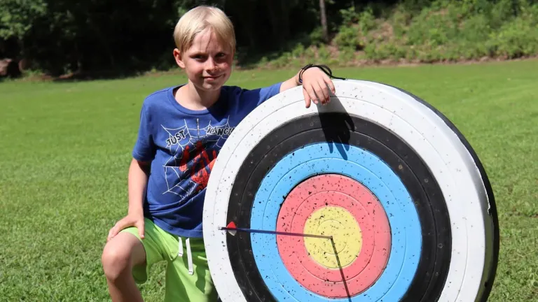 a boy with an archery target