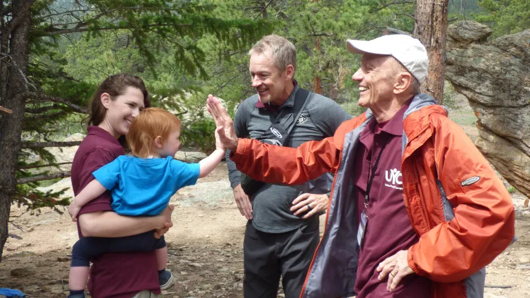 three adults and a child. The child is giving an adult a high five