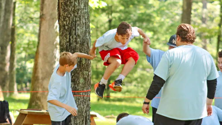 a boy jumping over a rope