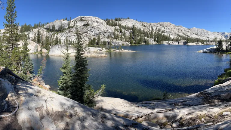a lake surrounded by white rocks and trees