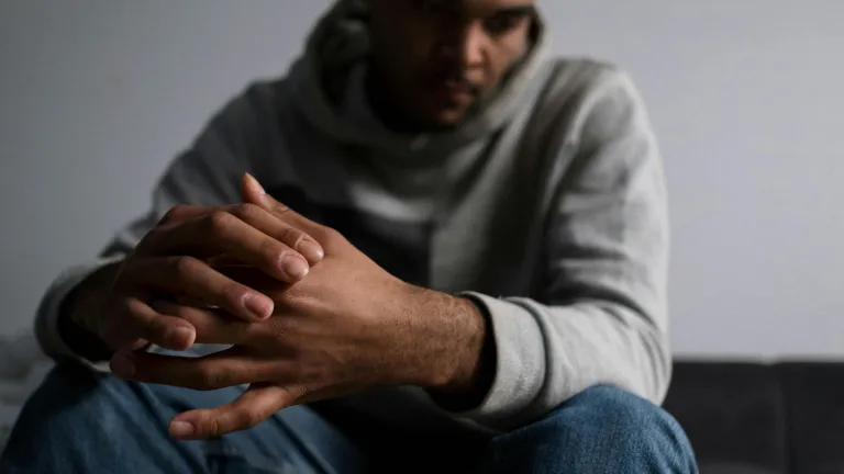 a sad man with folded hands