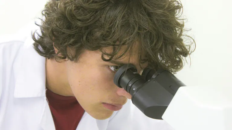 a man looking through a microscope
