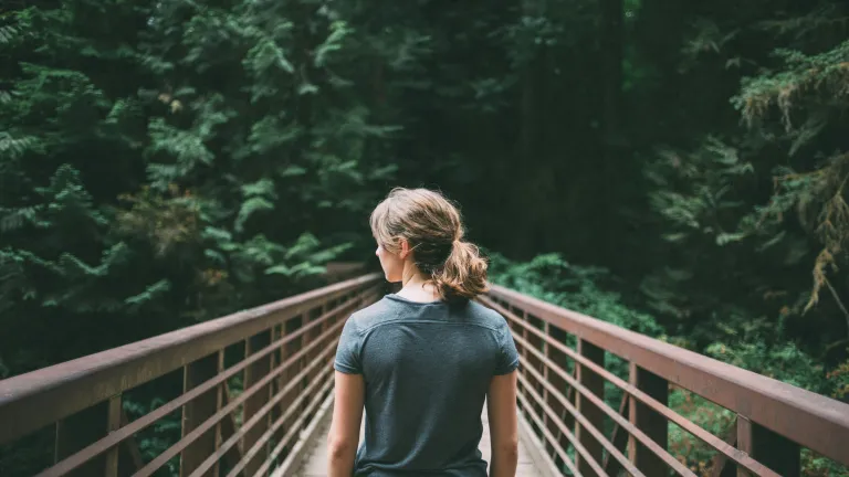 a woman on a bridge looking over the railing