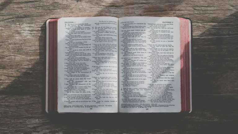 God's plan for mankind—is consistent from beginning to end. an open Bible on a wood table
