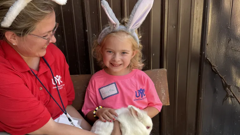a woman and a girl wearing bunny ears and holding a bunny