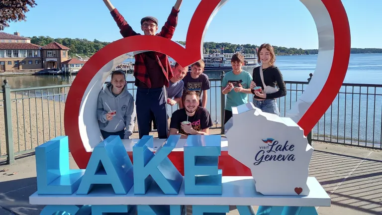 teenagers by a Lake Geneva sign with a heart