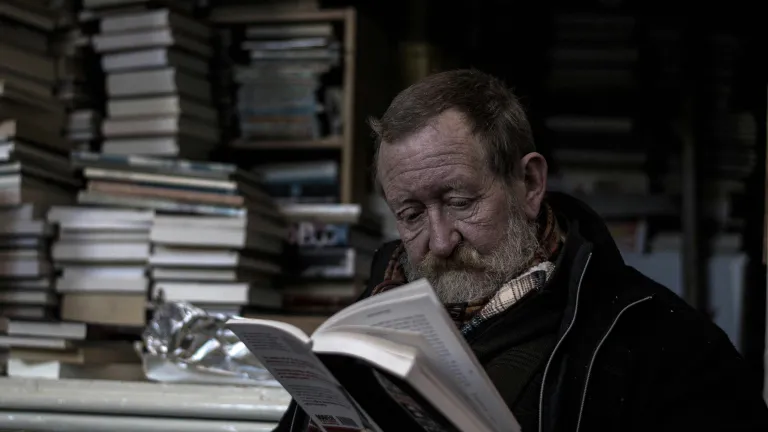 an old man reading a book