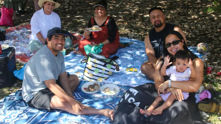 six people outside on a picnic mat