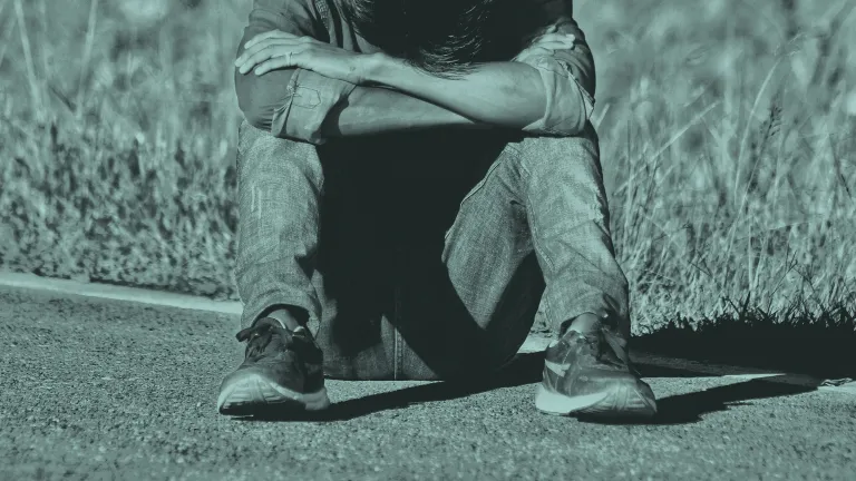 Person sitting with their head down