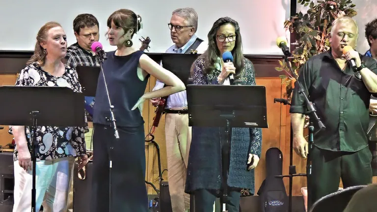 six people singing on a stage