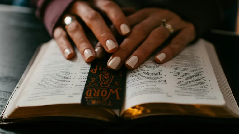 a woman's hands resting on an open Bible