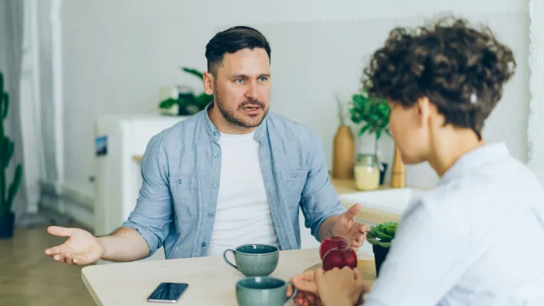 Two people sitting at a table in an intense conversation