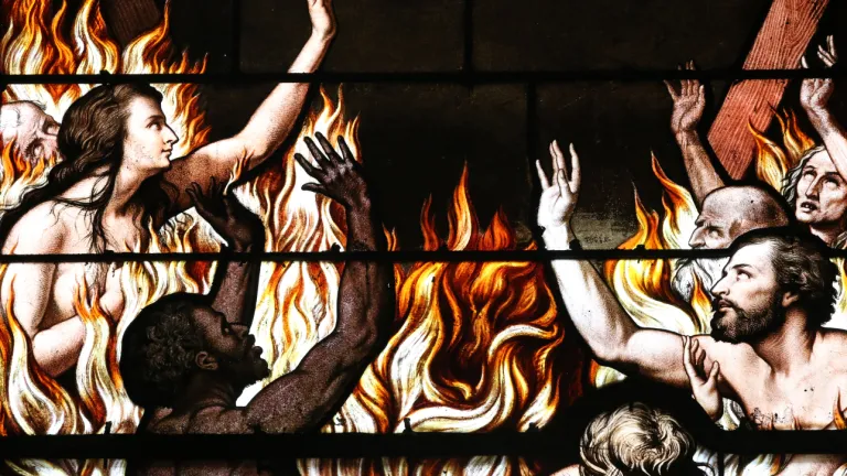 An artist rendition on stainglass of people burning in a fire.
