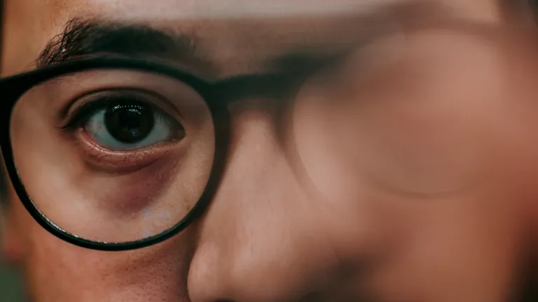 A blurry image of man's face wearing glasses.