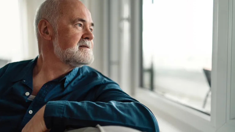 An man looking out a window.