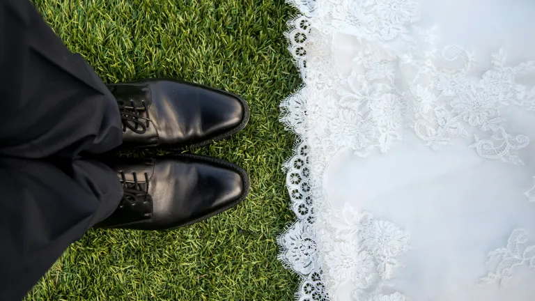 Interfaith relationships raise especially important questions for young adults. a view of a man's feet wearing black dress shoes standing across from the edge of a white lacy wedding dress
