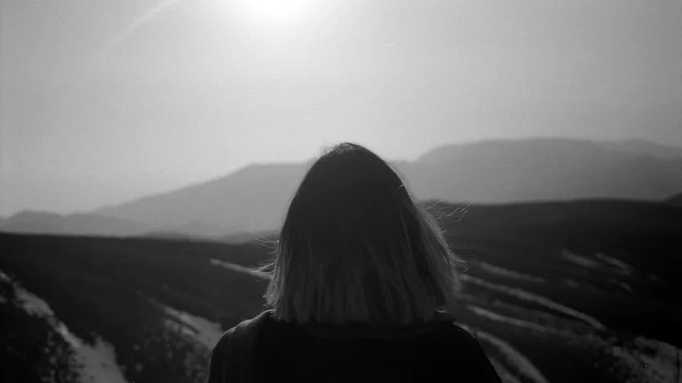 A woman looking at over a vista - a challenge to travel through.