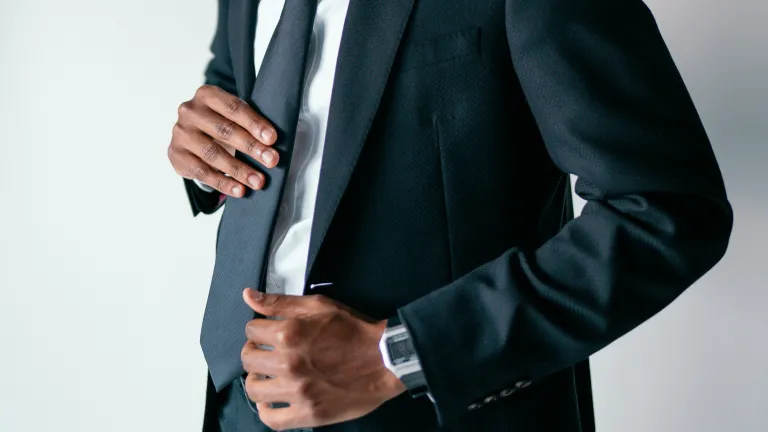 a man wearing a suit adjusting his tie