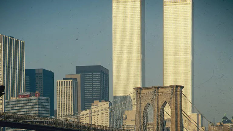 a historic image of the twin towers of the world trade center standing behind a bridge