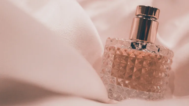 Many have some sort of allergy, and it is important to consider their needs. a glass bottle of perfume swathed in pink material