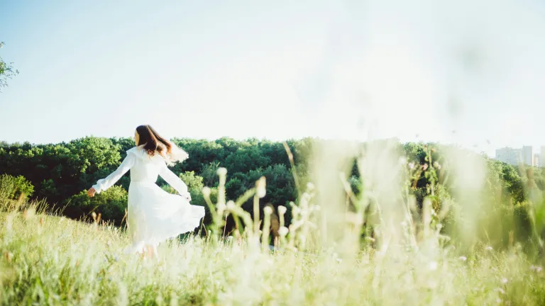 All who will live forever in God's divine family must experience the spiritual resurrection. woman in a white dress skipping through a field