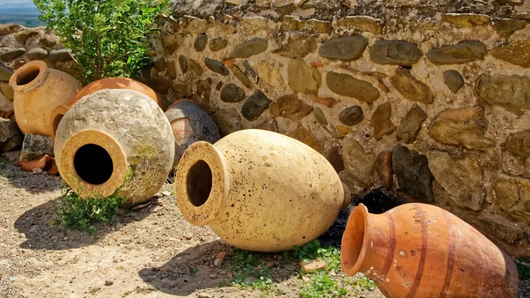 a stone wall and a line of ancient clay jars