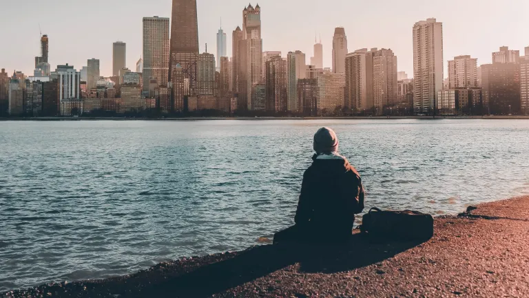True Christianity is based on the belief that there is absolute truth. A person sitting near the edge of water looking at a city skyline.