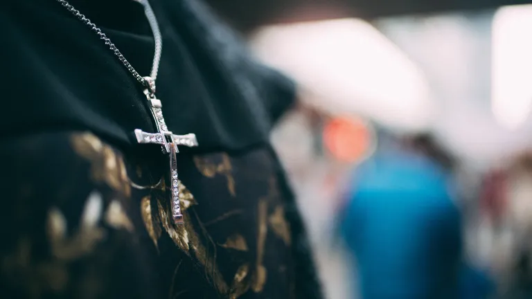 A person wearing a cross necklace.