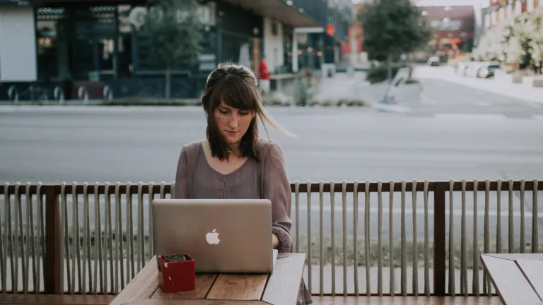 A young woman looking a laptop screen.