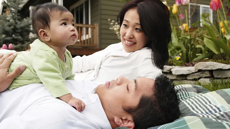 A husband and wife holding their baby.