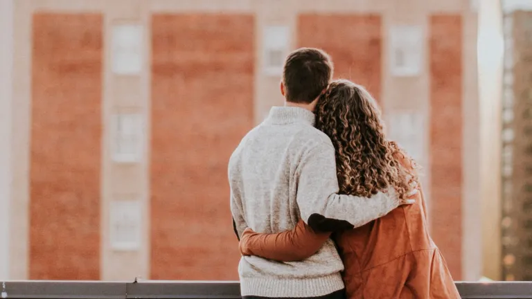A couple looking out over a wall.