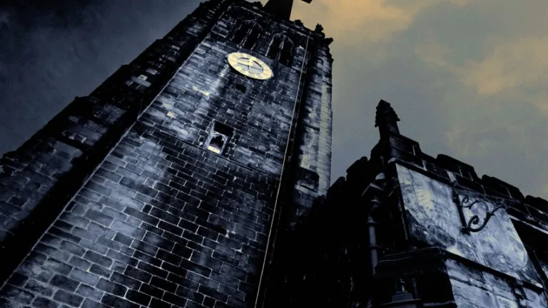 The first major trend prophesied in Revelation is the rise of false teachers claiming to represent Jesus Christ. Old church tower at night.