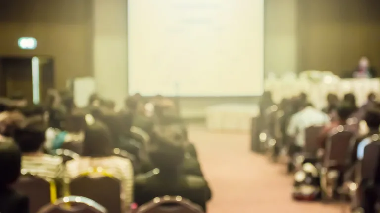 A group of people in a meeting hall.