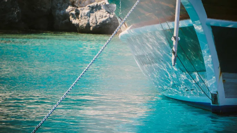 In the boating world there are different types of anchors for different conditions and sizes of boats. For us, there is only one anchor—God, our Rock. A boat in the water with a chain going down into the water attached to an anchor.