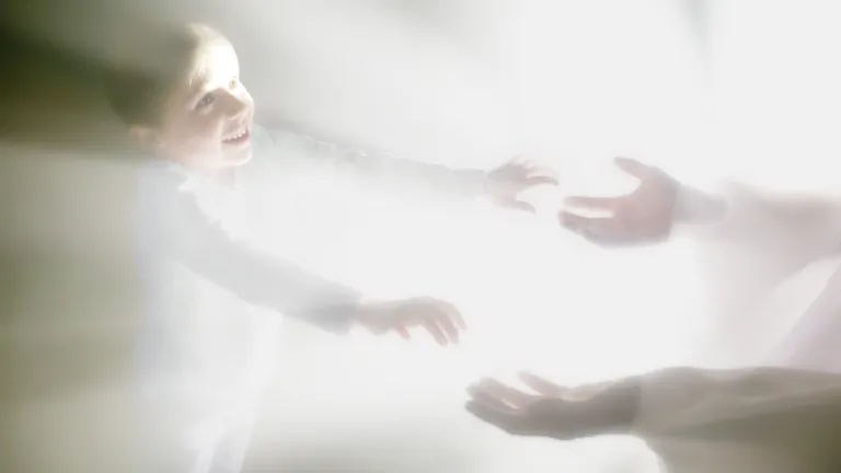 A photo illustration showing a person reaching for another person surrounded by bright lights.