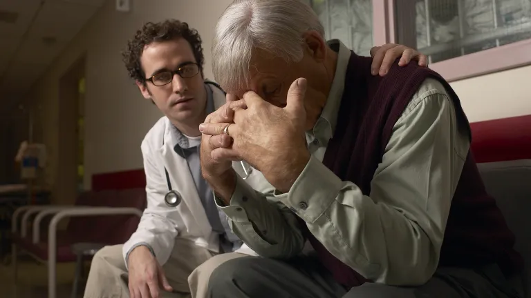 A doctor consoling a person who is grieving.