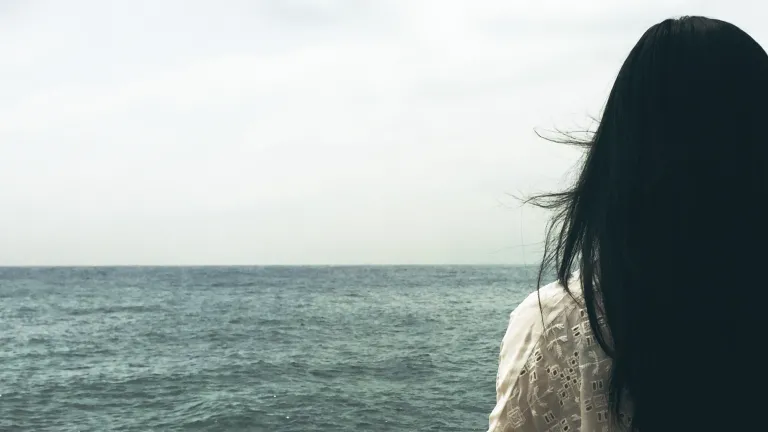 A woman looking out over a body of water.