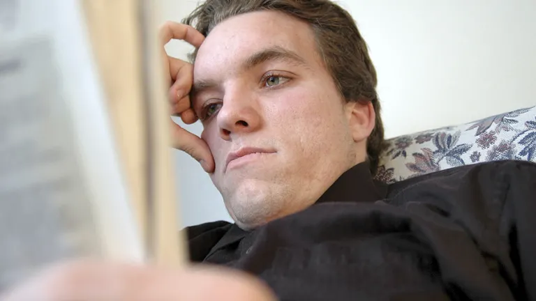 A worried looking man reading.