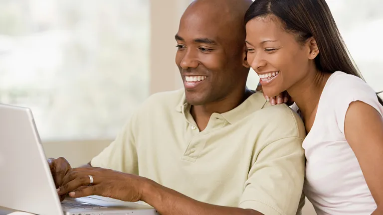 Prudent young couples should work and accumulate financial reserves before starting their families. A young couple looking at a laptop computer.