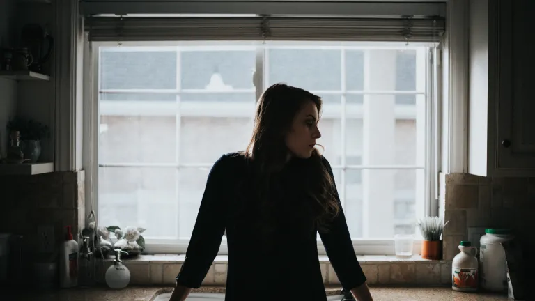 Faith is a deep conviction that God deeply cares for us and will always act with our best interests at heart. A woman standing by a kitchen sink.
