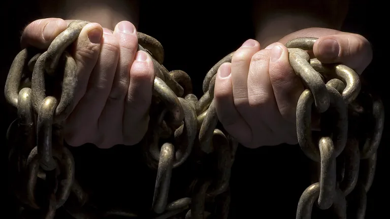 Hands holding chains.