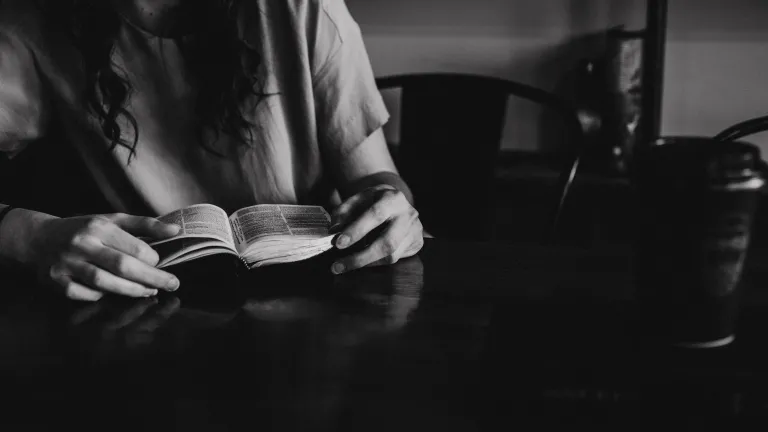 A woman reading a Bible in a coffee shop.