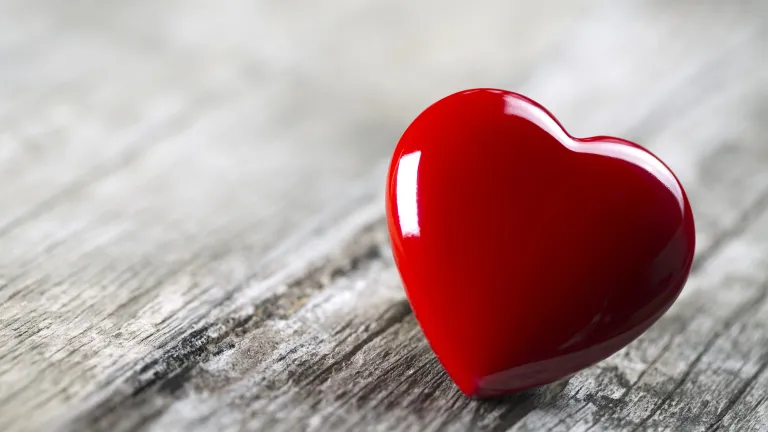 Valentine's Day it is definitely not a holiday with true Christian values. A round red heart laying on wood table.