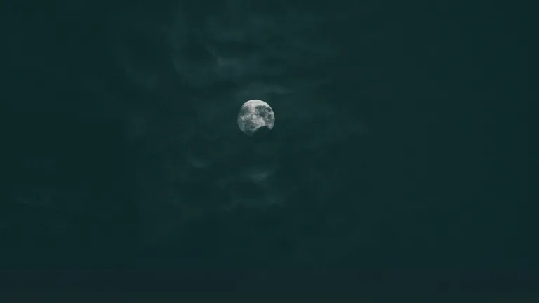 The moon through dark clouds.