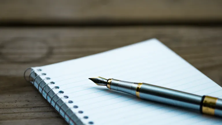 God’s instruction in Deuteronomy 17:18-20 states that kings were to write out a copy of God’s law and to read and rule by it continuously. A writing pen on top of spiral bound notebook.