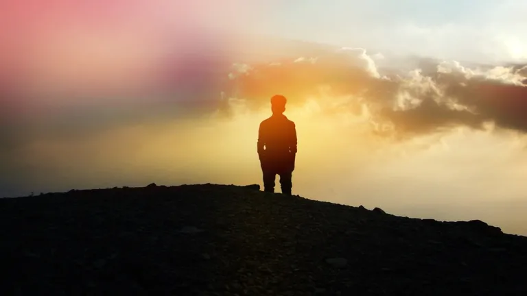 A person standing of top of a hill.