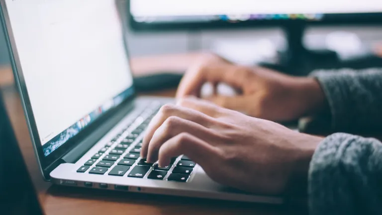 Question and think critically about the information you're given to avoid falling for any fake news. A man typing on a laptop computer.