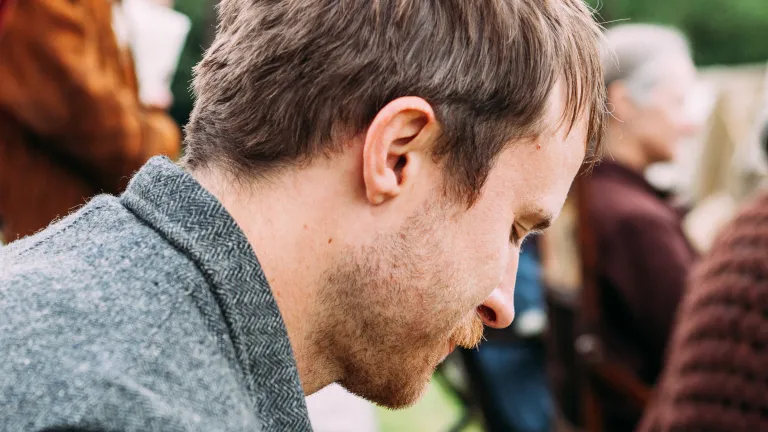 A man with his head down appearing to be grieving.