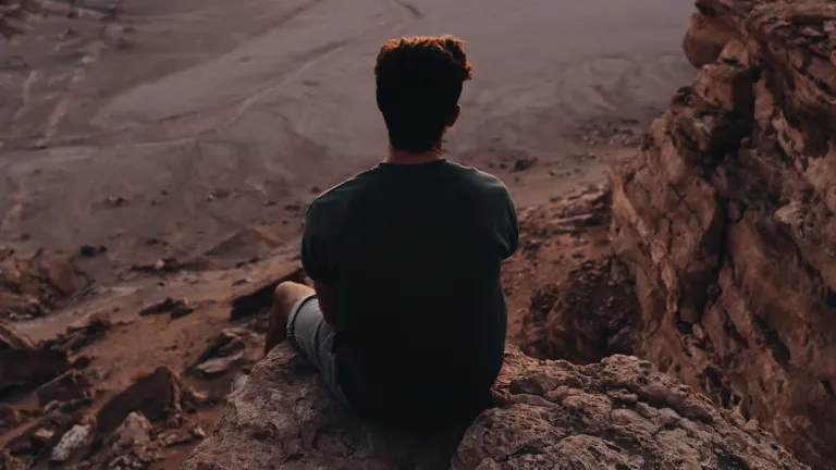 Not every Christian is called to face such extreme tribulation, but anyone truly seeking eternal life must possess the same deep conviction that would allow them to do so. A young man sitting on a rock cliff
